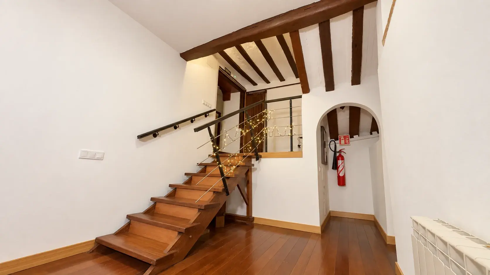 Escalera de madera con luces en la barandilla