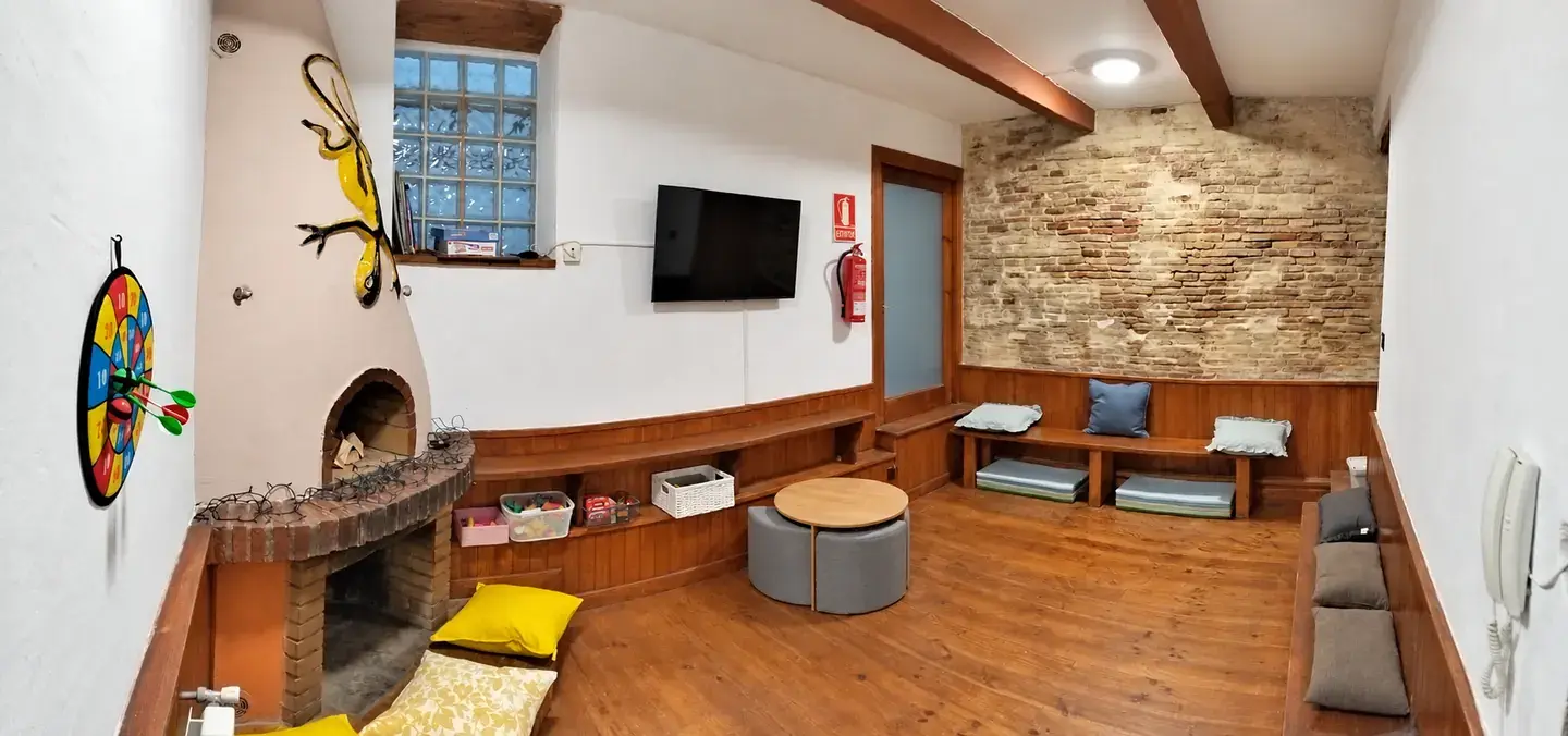 Vista general de la sala infantil con bancos, cojines y mesa de juegos