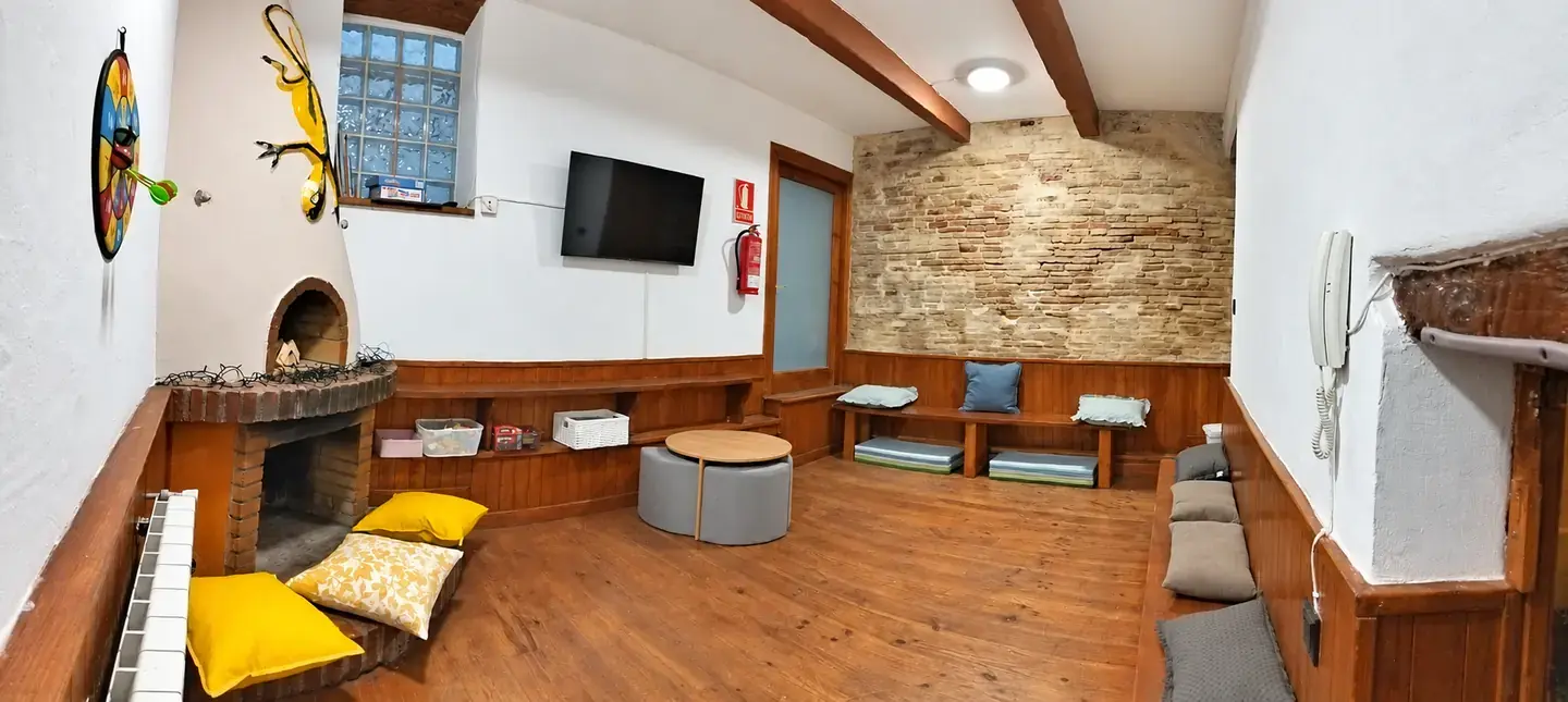 Rincón de juegos de la sala infantil con mesa, cojines y cestas