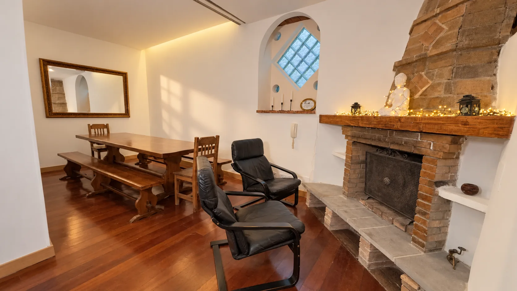 Salón con chimenea, sillones y mesa de comedor
